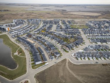 Saskatchewan, Saskatchewan 'daki Brighton banliyö mahallesini gösteren yüksek çözünürlüklü bir hava aracı fotoğrafı. Görüntü, açık bir günde konut, yeşil alanlar, sokaklar ve yakındaki konforların yerleşim yerlerini yakalıyor.