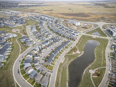 Saskatchewan, Saskatchewan 'daki Brighton banliyö mahallesini gösteren yüksek çözünürlüklü bir hava aracı fotoğrafı. Görüntü, açık bir günde konut, yeşil alanlar, sokaklar ve yakındaki konforların yerleşim yerlerini yakalıyor.