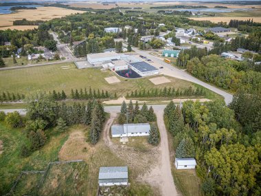 Middle Lake, Saskatchewan 'ın hava aracıyla çekilmiş bir fotoğrafı, konut evleri, ağaçlarla kaplı caddeler, yerel parklar ve çevresindeki tarım arazileri, bu küçük kırsal kesimin sükunetini yansıtıyor..