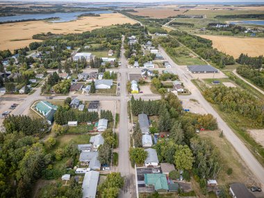 Middle Lake, Saskatchewan 'ın hava aracıyla çekilmiş bir fotoğrafı, konut evleri, ağaçlarla kaplı caddeler, yerel parklar ve çevresindeki tarım arazileri, bu küçük kırsal kesimin sükunetini yansıtıyor..