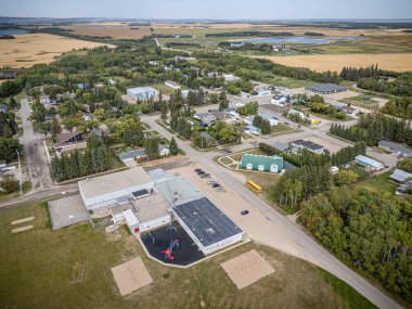 Middle Lake, Saskatchewan 'ın hava aracıyla çekilmiş bir fotoğrafı, konut evleri, ağaçlarla kaplı caddeler, yerel parklar ve çevresindeki tarım arazileri, bu küçük kırsal kesimin sükunetini yansıtıyor..