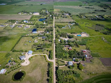 Gruenthal, Saskatchewan 'ın hava aracıyla çekilmiş bir fotoğrafı, etrafı tarım arazileri, açık araziler ve ağaçlarla çevrili küçük bir kırsal topluluğu gösteriyor..