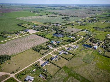 Gruenthal, Saskatchewan 'ın hava aracıyla çekilmiş bir fotoğrafı, etrafı tarım arazileri, açık araziler ve ağaçlarla çevrili küçük bir kırsal topluluğu gösteriyor..