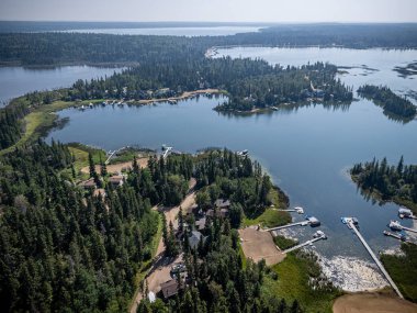 Emma Lake, Saskatchewan 'ın yaz aylarında çekilmiş hava aracı fotoğrafı. Deniz kenarındaki kulübeler, yemyeşil ormanlar, berrak göl ve dinlenme alanları, güzel ve huzurlu bir ortam yaratıyor..