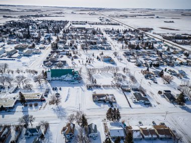 Wakaw, Saskatchewan 'ın kışın çekilen insansız hava aracı fotoğrafı, karla kaplı yerleşim alanları, sokaklar, parklar ve halka açık alanlar, resimli, karlı bir manzarayla çevrili..