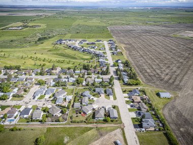 Delisle, Saskatchewan 'ın hava aracıyla çekilmiş bir fotoğrafı konut alanları, ağaçlarla kaplı caddeler, parklar ve manzaralı çayır manzarasıyla çevrili bu küçük kasabadaki konforlar..