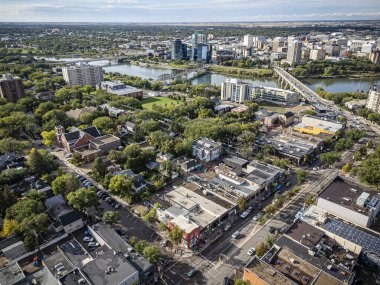 An aerial drone photo of the Nutana neighborhood in Saskatoon, Saskatchewan, highlighting historic homes, tree-lined streets, parks, and scenic views of the South Saskatchewan River in this vibrant community. clipart