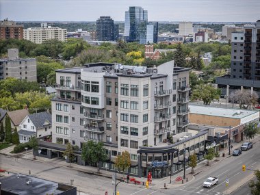 An aerial drone photo of the Nutana neighborhood in Saskatoon, Saskatchewan, highlighting historic homes, tree-lined streets, parks, and scenic views of the South Saskatchewan River in this vibrant community. clipart