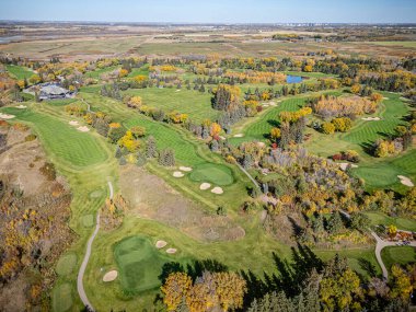 Saskatchewan, Saskatchewan 'daki Riverside Golf Sahasının hava aracı fotoğrafı manikürlü yeşillikleri, çayırları, ağaç çizgili delikleri ve Güney Saskatchewan nehrinin manzaralı manzarasını gösteriyor..