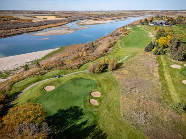 Saskatchewan, Saskatchewan 'daki Riverside Golf Sahasının hava aracı fotoğrafı manikürlü yeşillikleri, çayırları, ağaç çizgili delikleri ve Güney Saskatchewan nehrinin manzaralı manzarasını gösteriyor..
