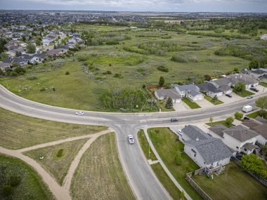 A high-resolution aerial drone photo of the Silverspring neighborhood in Saskatoon, Saskatchewan, highlighting residential homes, tree-lined streets, parks, and open green spaces in this family-friendly area. clipart