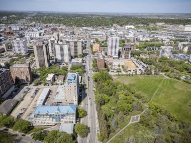 A high-resolution aerial drone photo of the City Park neighborhood in Saskatoon, Saskatchewan, showcasing tree-lined streets, historic homes, parks, and proximity to the South Saskatchewan River. clipart