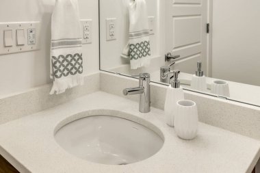 Üzerinde havlu asılı bir banyo lavabosu. Lavabo beyaz ve havlu mavi.