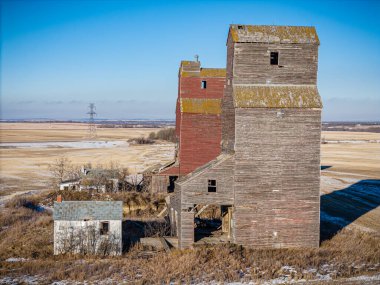 Büyük, eski bir tahıl ambarı bir tarlada oturur. Silo küçük bir ev ve birkaç bina ile çevrilidir. Gökyüzü açık ve güneş ışıl ışıl parlıyor. Sahne huzurlu ve sessiz.