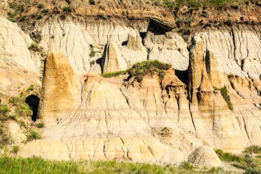 Birkaç küçük tepesi ve birkaç küçük kayası olan kayalık bir yamaç. Tepe tarafı çoğunlukla kahverengi ve kayalar çoğunlukla gridir.