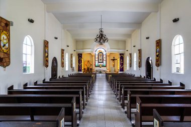 Kilise boş ve sıralar da boş. Kilise çok büyük ve bir sürü penceresi var.