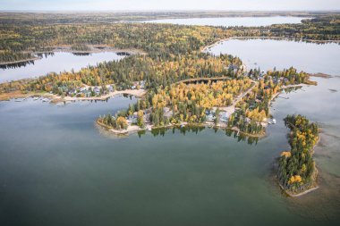 Ortasında küçük bir ada olan güzel bir göl. Ada ağaçlar ve evlerle çevrili.