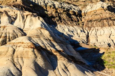 Etrafa dağılmış birkaç küçük kayalık bir yamaç. Kayaların boyutları ve şekilleri farklıdır ve yamaçta da toprak tabakası vardır.