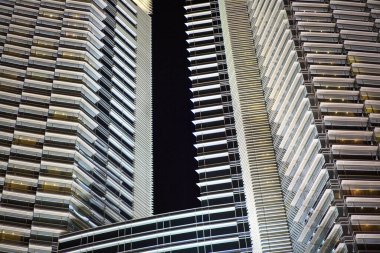 Bir sürü penceresi ve karanlık gökyüzü olan yüksek bir bina. Bina geceleri aydınlanıyor ve kasvetli bir atmosfer yaratıyor. Karanlık gökyüzü arasındaki zıtlık