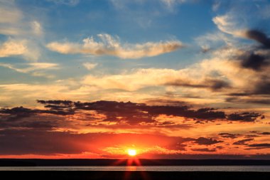 Gökyüzü mavi ve turuncu renklerin güzel bir karışımıdır. Güneş uzaklardan batar.