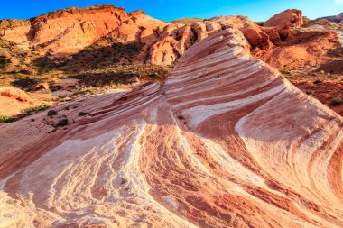 Üzerinde beyaz bir şerit olan kayalık bir yamaç. Tepe kırmızı ve beyaz kayalarla kaplı.