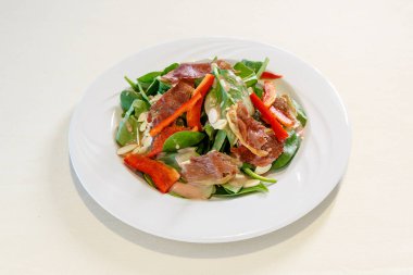 Üzerinde salata olan bir tabak yemek. Salata ıspanak, biber ve etten oluşur.