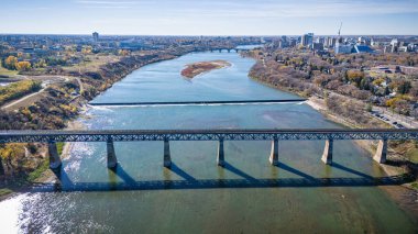 Köprü, üzerinden tren geçen bir nehri kapsar. Köprü ağaçlar ve binalarla çevrili. Sahne huzurlu ve huzurlu bir atmosfer sağlıyor.