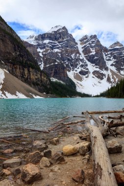 Önünde göl olan güzel bir dağ sırası. Göl mavi ve kayalarla çevrili.