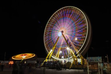 Dönen tekerli ve atlı karnaval gezisi. Karnaval gece ve ışıklar açık.