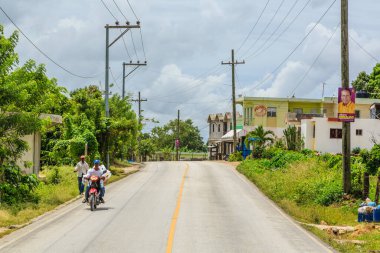 Motosikletli bir adam motosikletli bir adamla birlikte yolda ilerliyor. Yol boş ve olay yerinde başka kimse ya da araç yok.