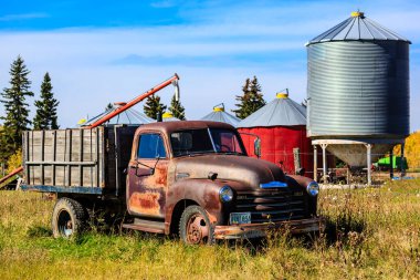 Eski bir kamyon bir ambarın yanındaki arazide park halinde. Kamyon paslanmış ve bir sürü karakteri var. Silo uzun ve metaliktir ve ağaçlarla çevrilidir. Sahnenin bir köylüsü var.