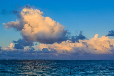 Okyanusun üzerinde büyük bir bulut var. Gökyüzü mavi ve bulutlar beyaz