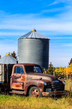 Eski bir kamyon bir ambarın yanında park halinde. Kamyon paslanmış ve silo uzun ve metalik. Sahne sessiz ve huzurlu, tek ses otların hışırtısı.