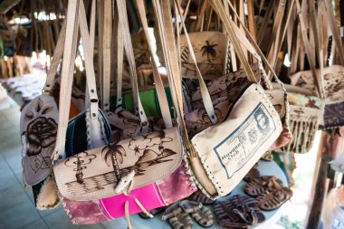 Tavandan sarkan bir çanta koleksiyonu. Bazılarında bir adamın resmi var.