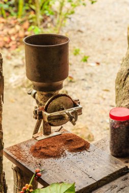 Kahve öğütücüsü, bir kavanoz kahve çekirdeğinin yanındaki ahşap masada oturur. Öğütücü eski ve paslı, ve fasulyeler etrafa saçılmış. Sahne, köylü havası veriyor.