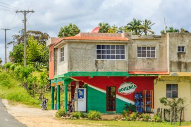 Bohemya yazan kırmızı ve yeşil işareti olan küçük bir bina. Bir adam binanın dışında motosikletin üzerinde oturuyor.