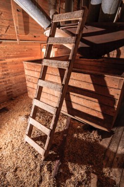 Tahta bir yapıya dayanan bir merdiven var. Merdiven ahşaptan yapılmıştır ve kırsal bir görünüşü vardır.