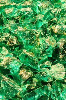 Yeşil cam kırıkları yığını. Parçaların hepsi farklı boyutlarda ve şekillerde. Yeşil renk rahatlatıcı olduğu için, görüntü rahatlatıcı ve dingin bir ruh haline sahip.