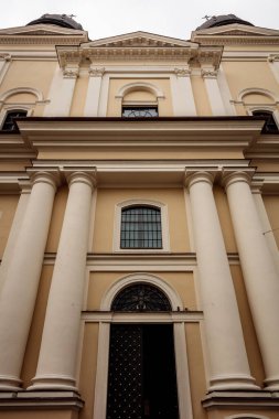 Bina yüksek ve bir sürü penceresi var. Bu bir kilise. Pencereler çoğunlukla siyah ve bina beyaz.