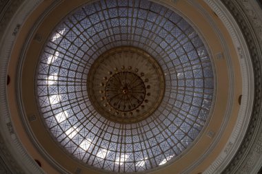 Üzerinde altın bir avize asılı büyük bir kubbe. Avize birçok küçük ışıkla çevrilidir.