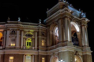 Yeşil ışığı olan büyük bir bina. Bina gece aydınlanıyor. Bina eski ve çok detay içeriyor.