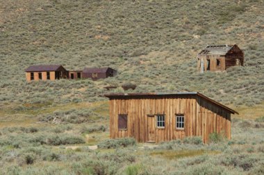 Çölün ortasında küçük ahşap bir ev duruyor. Ev, hepsi eski ve terk edilmiş birkaç başka evle çevrili. Çöl manzarası çorak ve ıssız.