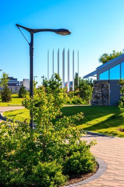 Arka planda sokak lambası ve binası olan bir park. Sokak lambası görüntünün solunda.