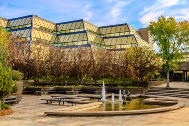 Önünde çeşme olan büyük bir bina. Çeşmede kuş heykelleri var.