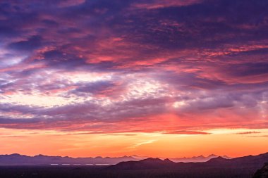 Pembe ve turuncu gökyüzü olan güzel bir gün batımı. Gökyüzü bulutlarla dolu ve güneş batıyor.