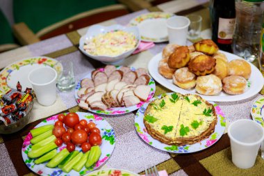 İçinde kek ve birkaç fincan da dahil olmak üzere çeşitli yiyecekler olan bir masa. Masa yemek için hazır.