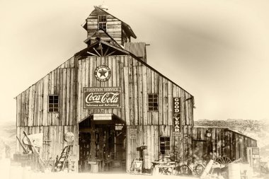 Önünde Coca-Cola işareti olan büyük, eski moda bir bina. Bina bir sürü ıvır zıvırla çevrili ve içinde bir sürü eski moda eşya var.