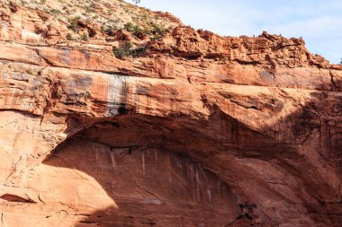 Ortasında küçük bir delik olan büyük bir kaya oluşumu. Delik kırmızı kayadan bir duvarla çevrili.