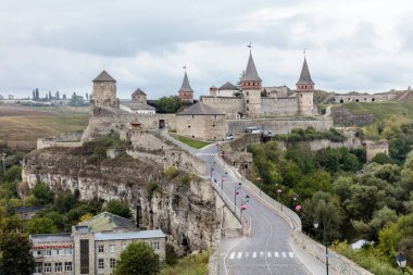 Nehrin üzerinde köprüsü olan ve üzerinde yürüyen birkaç kişi olan bir kale. Kale eski ve uzun bir geçmişi var.