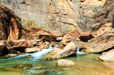 Bir nehir kayalık bir kanyondan akar. Su temiz ve kayalar büyük. Huzurlu ve huzurlu bir sahne.